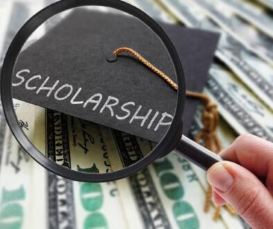 Scholarship graduation cap on money with magnifying glass